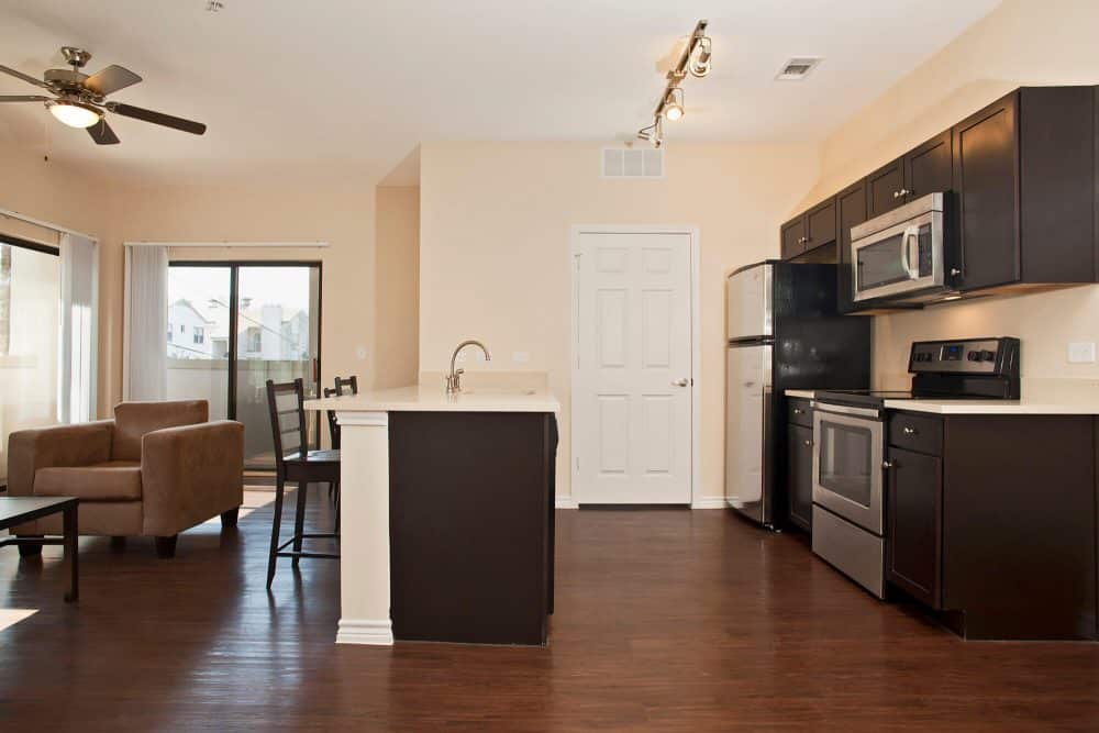 axis west campus off campus apartments in west campus near ut austin open floor plan kitchen and living room vacant move in ready furniture packages available